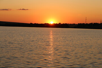 A body of water with a sunset in the background © parpalac