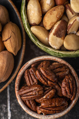 Nuts mix in ceramic plates on black table.