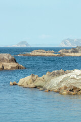 Sea surrounded by a rocky coastal area during a sunny day, concept travel, relaxing, copy space, vertical shot.