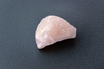 Rose quartz, stone silicate mineral. Rough, uncut, pinkish color, black background