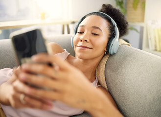 Headphones, happy and woman with a smartphone, streaming music and listening to audio, podcast and relax. Headset, female person or model on a couch, cellphone and wellness with song, calm and radio