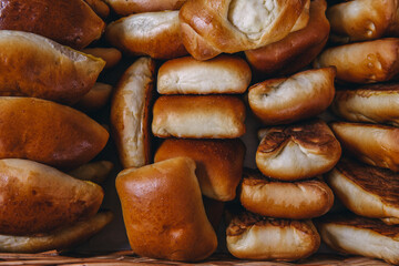 Many freshly baked buns in the basket. Top view bread. Pies, bun, baking