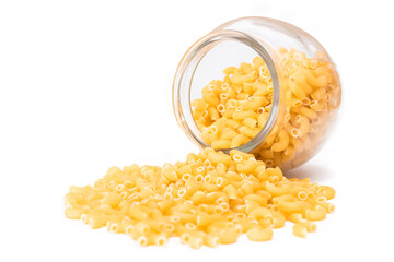 Uncooked Chifferi Rigati Pasta in Glass Jar Isolated on White Background. Fat and Unhealthy Food. Scattered Classic Dry Macaroni. Italian Culture and Cuisine. Raw Pasta