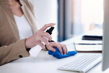 Keyboard sanitize, woman hand and spray at a desk for bacteria safety in a office. Business person, company and computer cleaner with bottle for covid, virus and germ protection against infection