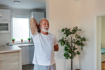 Mature adult man doing yoga at home during the outbreak.