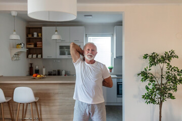 Portrait, fitness and stretching with a senior man athlete doing a warm up for exercise or training. Man stretching arms before workout at home.