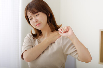 肩が痛そうな若い女性