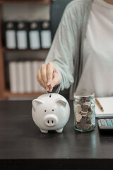Close up young woman saving money for household payments coin,  piggy bank, mutual fund, mixed...