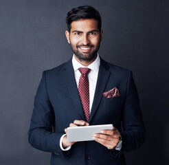 Businessman, tablet and smile in studio, dark background or research stock market trading news online. Corporate trader, indian man or digital technology for investment management, finance or website - obrazy, fototapety, plakaty