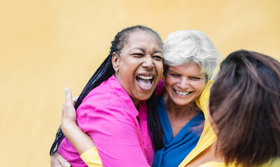 Happy senior female people hugging and having fun together - Older friends international community concept - Focus on african woman face