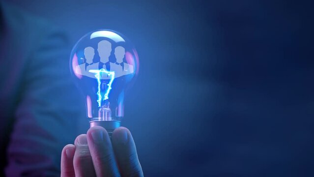 Businessman shows human icon in glowing light bulb for human resources or leadership and creativity thinking idea motivation or vision and knowledge learning and study or education concept.