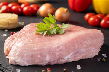 Fresh raw pork meat. A piece raw pork shoulder with spices and vegetables on a slate board. Pork tenderloin. Pulpa, carne de porc. 