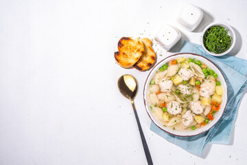 Homemade soup with chicken and turkey meatballs, shell Conchiglie pasta and vegetables, with greens. White meat broth with vegetables and macaroni, healthy diet food, children's lunch