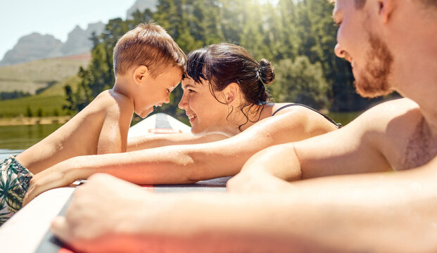 Nature, bonding and family swimming in a lake together while on vacation or adventure in the woods. Happy, love and mother embracing her boy child while having fun in pond on holiday or weekend trip. - Powered by Adobe
