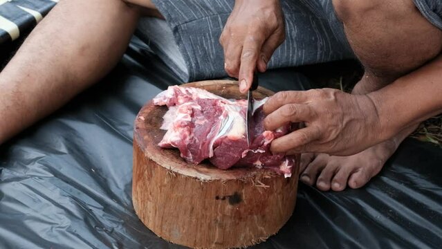 Muslims cutting meat slaughtering during Eid Al-Adha Al Mubarak, the Feast of Sacrifice or Qurban