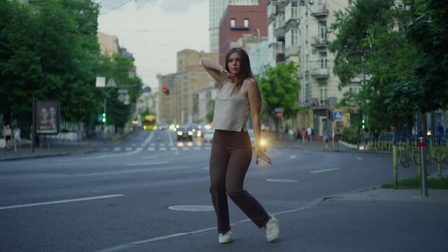 Stylish Caucasian woman dancing on the city street. Urban landscape and modern dancing of a sexy girl in a cityscape. High quality 4k footage
