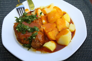 ossobuco with potatoes, sauce and gremolata, italian food, close up,
