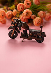 Motorcycle day background with copy space for greeting text, Wooden motorcycle isolated on light pink colour background