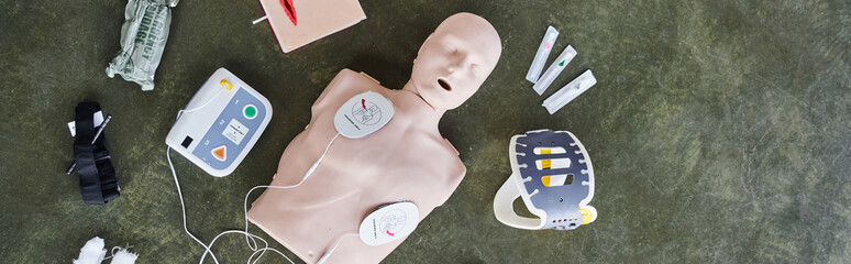 top view of automated external defibrillator, neck brace, syringes, compression tourniquet and...