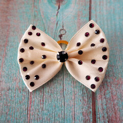 on a blue wooden background lies a small bow with a shiny black stone in the middle with...