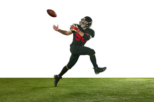 Concentrated man, american football player in black uniform in motion, running and catching ball against white background. Concept of professional sport, action, lifestyle, competition, training, ad
