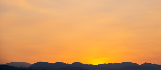 Orange sky over silhouette mountain in the morning.