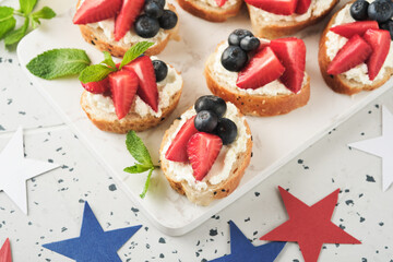 American flag sandwich with strawberries, blueberries, whipped sweet cream, soft cheese on toast bread. 4th of July American Independence Day food. Independence or Patriotic Day breakfast idea Mock up