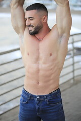 Obraz premium El cuerpo masculino perfecto - Impresionante simulador de cuerpos posando. Joven musculoso sin camiseta mirando hacia otro lado con gran sonrisa Espacio para texto