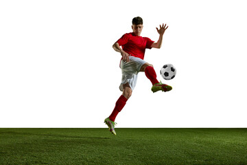 Young athletic man, football, soccer player in uniform training, kicking ball with leg against...