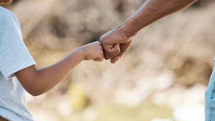 Support, love and father and child with fist bump for motivation, care and trust in nature. Family, collaboration and hands of dad and kid together for community, cooperation or achievement in a park