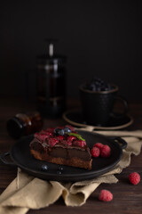 Still life with a piece of chocolate brownie cake with raspberries
