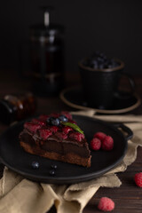Still life with a piece of chocolate brownie cake with raspberries