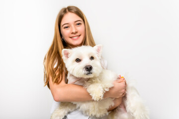 Girl and West Highland Terrier wearing white shirt on studio shot