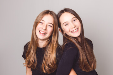 Two Young pre teen best friend girl on studio white