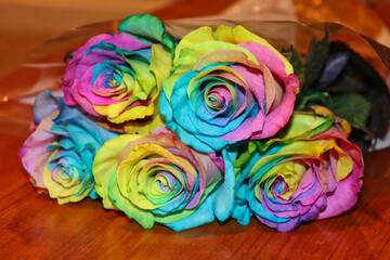 Fototapeta na wymiar Rainbow rose bouquet on wood table