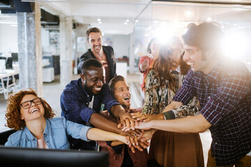 Group of young people celebrating a successful job in the office together