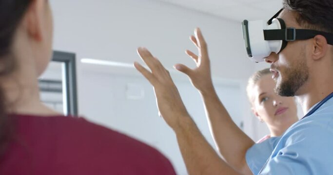Diverse male and female doctors using vr headset at hospital, slow motion