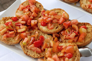 Apulian friselle, typical summer food from Puglia, South Italy. Crunchy donuts made from durum wheat flour seasoned with tomatoes and olive oil