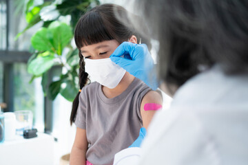 Doctor is affixing the medicinal plaster after vaccinated in shoulder of Asian girl kids in...