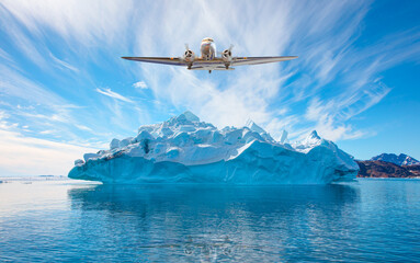 Propeller airliner flying over glaciers - Melting icebergs by the coast of Greenland, on a beautiful summer day - Melting of a iceberg and pouring water into the sea - Greenland