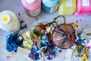 Cleaning inkjet printer with stained ink tissue paper and colors bottle on vinyl