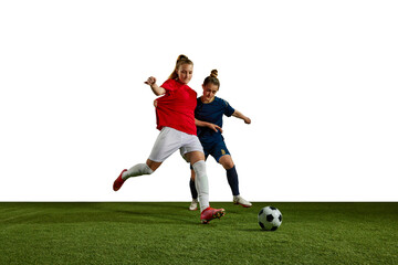 Two young girls, football players in motion, training, dribbling ball against white background. Sportschool. Concept of professional sport, action, lifestyle, competition and hobby, training, ad