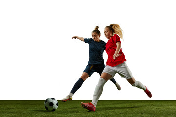 Fototapeta na wymiar Two young girls, football players in motion, training, dribbling ball against white background. Sportschool. Concept of professional sport, action, lifestyle, competition and hobby, training, ad
