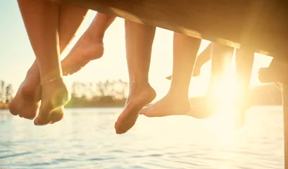 Foto op Plexiglas Group, feet on water and friends together at ocean, pier or outdoor in summer, vacation or freedom in holiday break. Teen, foot and children to relax at the lake, harbor or river on the weekend © HockleyMedia/peopleimages.com