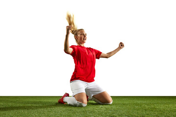 Happy young girl, football player sitting on sport field grass with winning gestures against white...