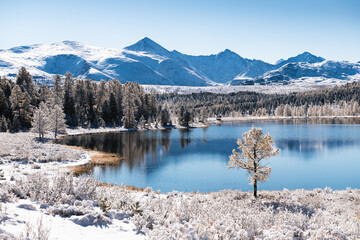 Kidelu lake in Altai mountains, Siberia, Russia. Snow-covered trees and mountains.