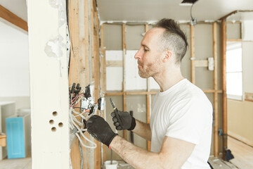 male electrician works working on a old house