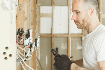 male electrician works working on a old house