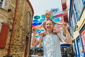 Obraz premium father and daughter in summer season in front of umbrella in quebec city