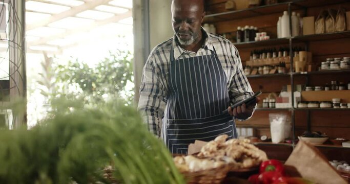 Senior african american male shopkeeper making inventory at health food shop, slow motion